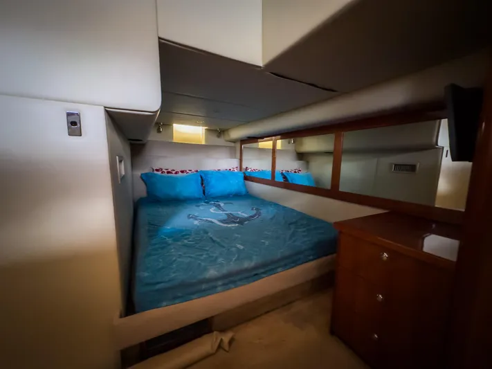  Yacht Photos Pics Luxurious bedroom interior of 2012 Riviera 50SY yacht with blue bedding and wooden accents.
