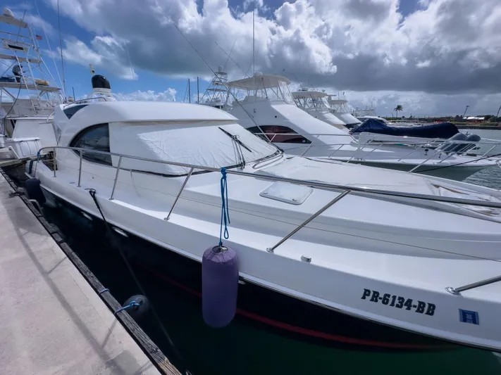  Yacht Photos Pics 2012 Riviera 50SY yacht docked at marina under cloudy sky.