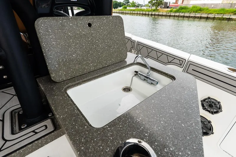  Yacht Photos Pics 2021 Wellcraft 402 Fisherman boat sink with speckled countertop, docked by the water.