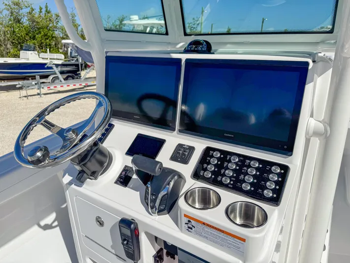  Yacht Photos Pics 2024 Caymas 28 HB boat dashboard with dual screens and steering wheel.