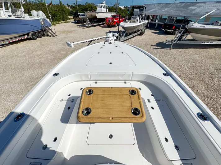  Yacht Photos Pics 2024 Caymas 28 HB boat deck with wooden table, docked in a marina.