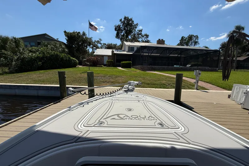  Yacht Photos Pics 2024 Contender 26 Bay boat docked, featuring Aqua Traction deck, sunny day, waterfront home.