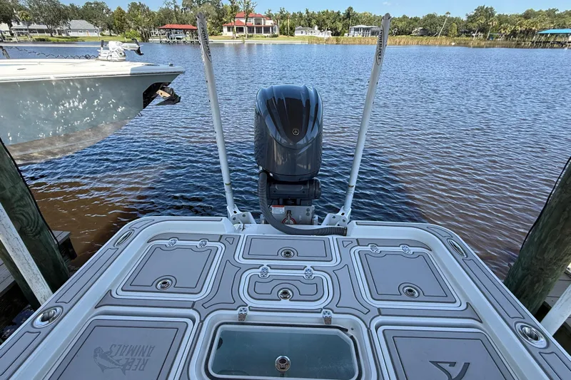  Yacht Photos Pics 2024 Contender 26 Bay boat docked by a serene waterfront, showcasing its sleek design.