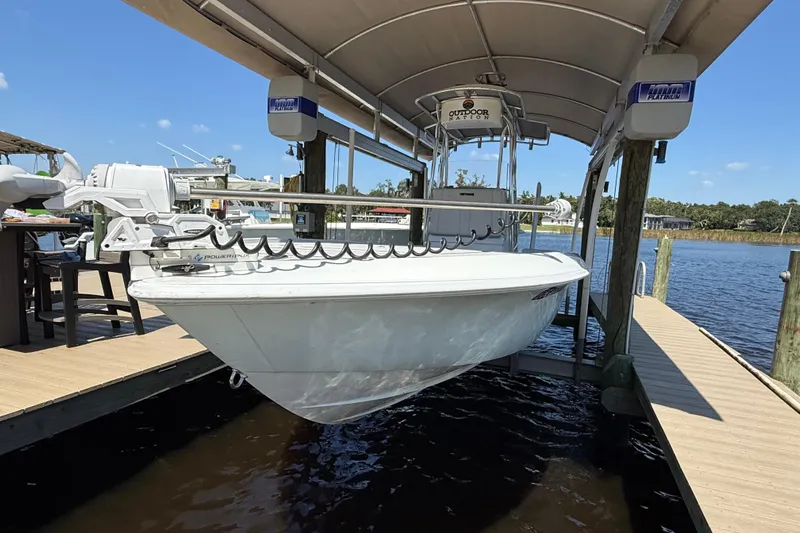  Yacht Photos Pics 2024 Contender 26 Bay boat docked under a canopy on a sunny day.