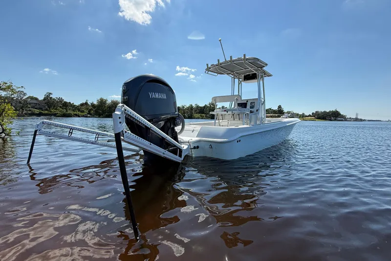  Yacht Photos Pics 2024 Contender 26 Bay boat with Yamaha engine on calm water under clear sky.