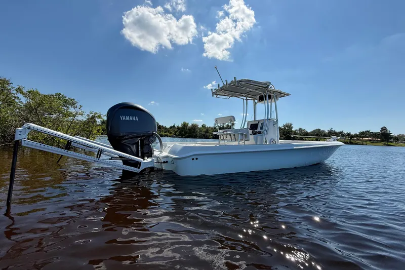  Yacht Photos Pics 2024 Contender 26 Bay boat on calm water with Yamaha engine, under clear blue sky.