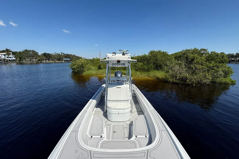  Yacht Photos Pics 2024 Contender 26 Bay boat on calm water near lush green shoreline.