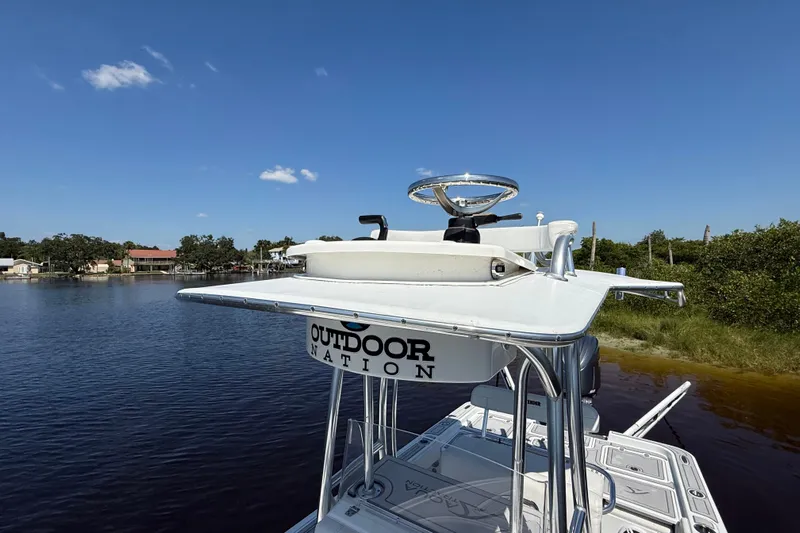  Yacht Photos Pics 2024 Contender 26 Bay boat with elevated helm, on a calm waterway under clear blue skies.