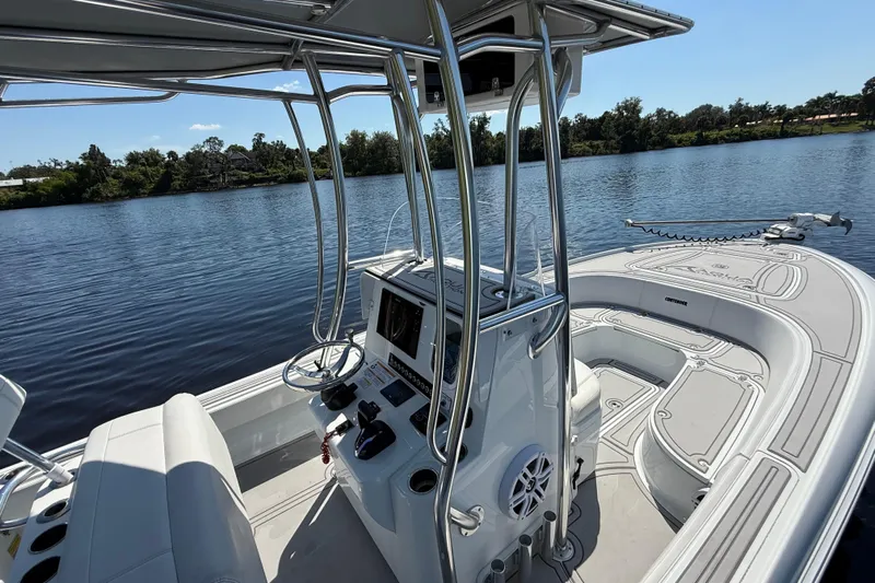  Yacht Photos Pics 2024 Contender 26 Bay boat interior with steering console on a calm lake.