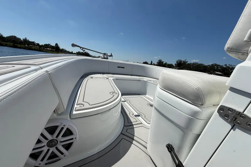  Yacht Photos Pics 2024 Contender 26 Bay boat interior with white seating and speaker, under clear blue sky.