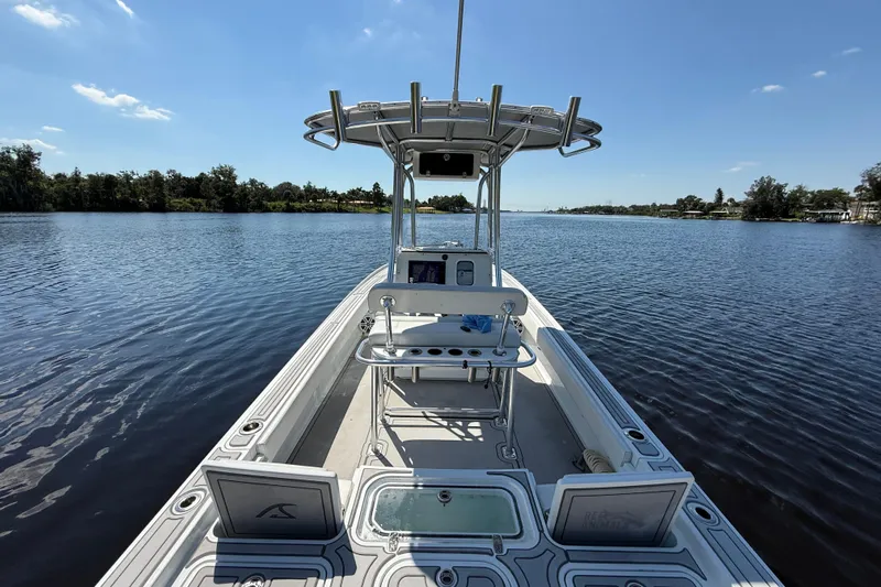  Yacht Photos Pics 2024 Contender 26 Bay boat on a calm lake under a clear blue sky.