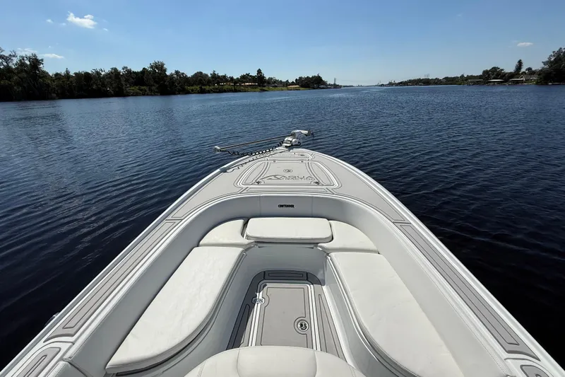  Yacht Photos Pics 2024 Contender 26 Bay boat on calm water, showcasing sleek design and spacious seating.