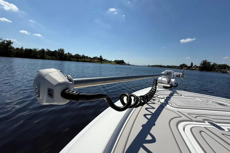  Yacht Photos Pics 2024 Contender 26 Bay boat on a serene lake under a clear blue sky.