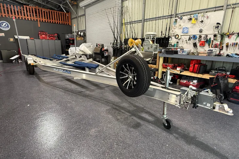  Yacht Photos Pics 2024 Contender 26 Bay boat trailer in a workshop with tools and equipment.