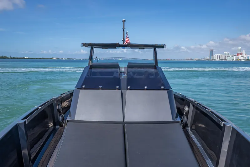  Yacht Photos Pics Luxury Wally 43 yacht cruising on clear blue waters, city skyline in background.