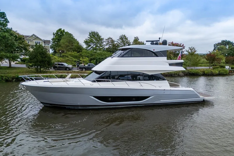 Norfolk Girl Yacht Photos Pics 2023 Maritimo M55 yacht on a serene river with lush greenery.