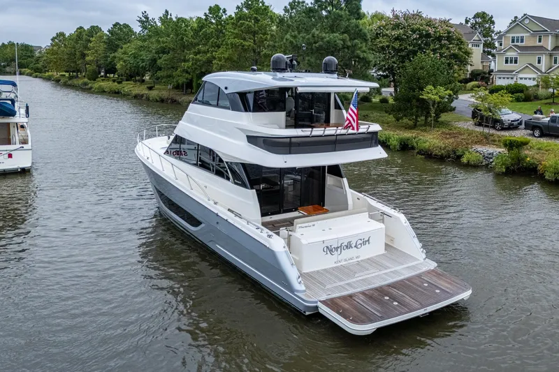 Norfolk Girl Yacht Photos Pics 2023 Maritimo M55 yacht cruising on a scenic river with lush greenery.