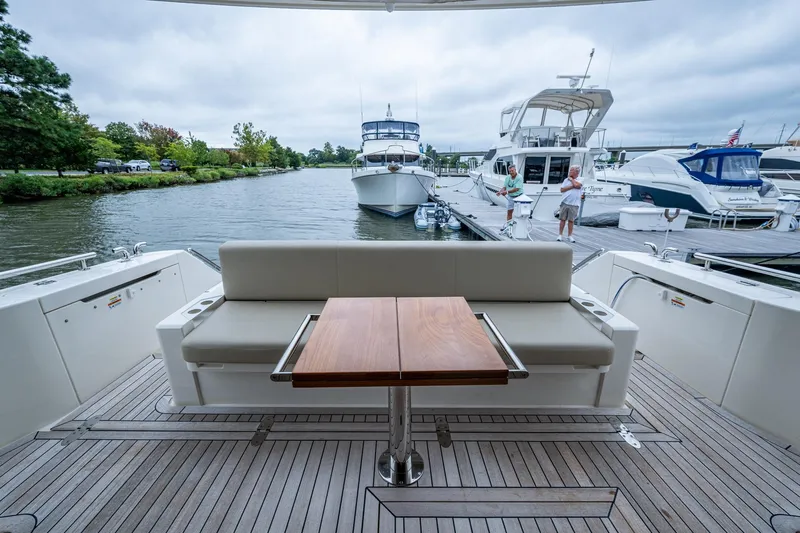 Norfolk Girl Yacht Photos Pics 2023 Maritimo M55 yacht with elegant deck seating and table at a marina.