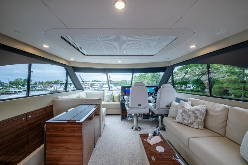 Norfolk Girl Yacht Photos Pics Luxurious interior of 2023 Maritimo M55 yacht with modern seating and panoramic windows.