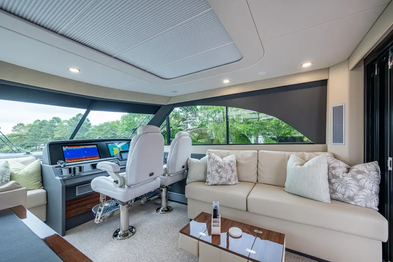 Norfolk Girl Yacht Photos Pics Luxurious interior of 2023 Maritimo M55 yacht with plush seating and modern helm.