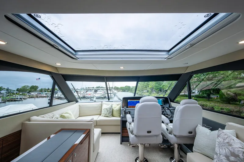 Norfolk Girl Yacht Photos Pics Luxurious interior of 2023 Maritimo M55 yacht with panoramic windows and plush seating.