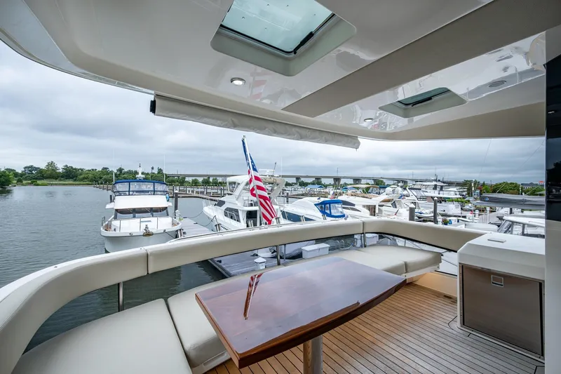 Norfolk Girl Yacht Photos Pics Luxurious 2023 Maritimo M55 yacht deck with elegant seating and scenic marina view.