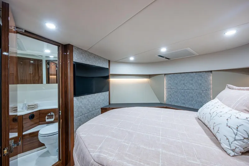 Norfolk Girl Yacht Photos Pics Luxurious 2023 Maritimo M55 yacht bedroom with ensuite bathroom, modern design, and elegant decor.