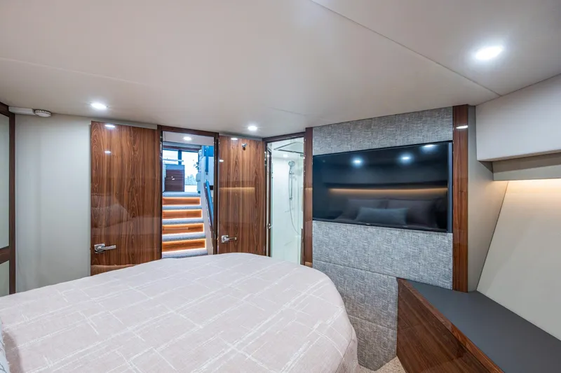 Norfolk Girl Yacht Photos Pics Luxurious interior of 2023 Maritimo M55 yacht bedroom with modern design and large TV.