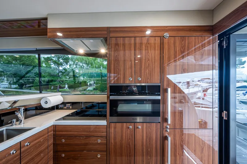 Norfolk Girl Yacht Photos Pics Luxurious kitchen interior of 2023 Maritimo M55 yacht with modern appliances and wood finish.
