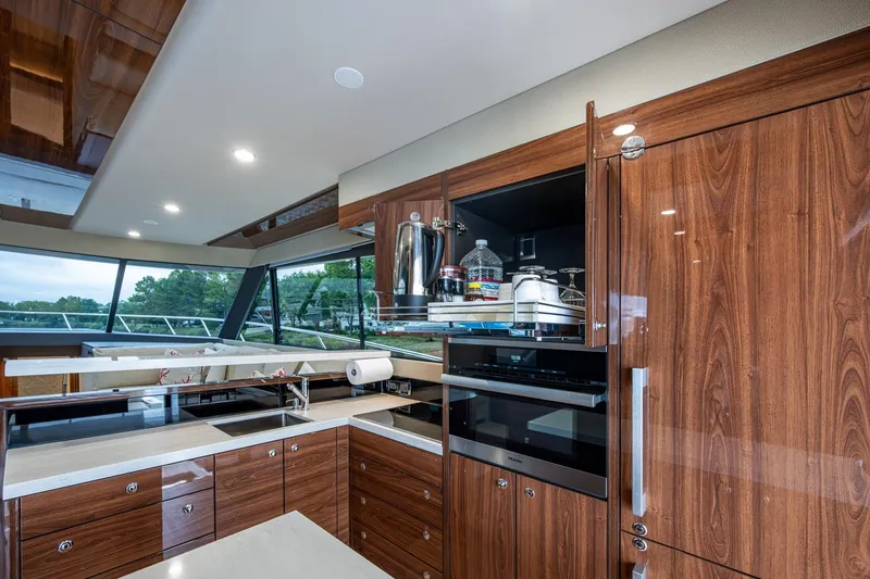 Norfolk Girl Yacht Photos Pics Luxurious 2023 Maritimo M55 yacht kitchen with modern wood cabinetry and sleek appliances.