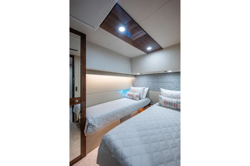 Norfolk Girl Yacht Photos Pics Luxurious twin bedroom in 2023 Maritimo M55 yacht, featuring modern design and ambient lighting.