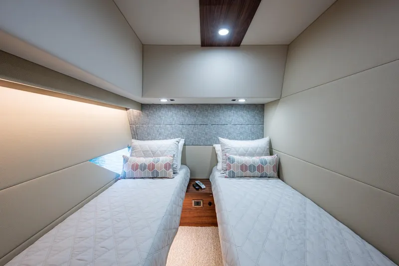 Norfolk Girl Yacht Photos Pics Luxurious twin cabin interior of 2023 Maritimo M55 yacht, featuring modern design and cozy bedding.