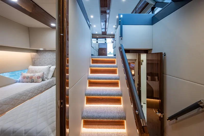 Norfolk Girl Yacht Photos Pics Luxurious interior of 2023 Maritimo M55 yacht with illuminated stairs and cozy bedroom.