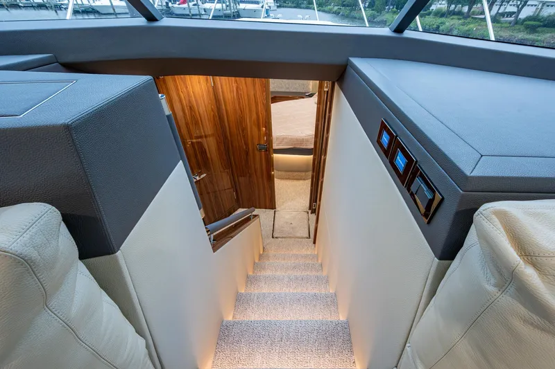 Norfolk Girl Yacht Photos Pics Interior view of 2023 Maritimo M55 yacht, featuring elegant stairs and wooden door.