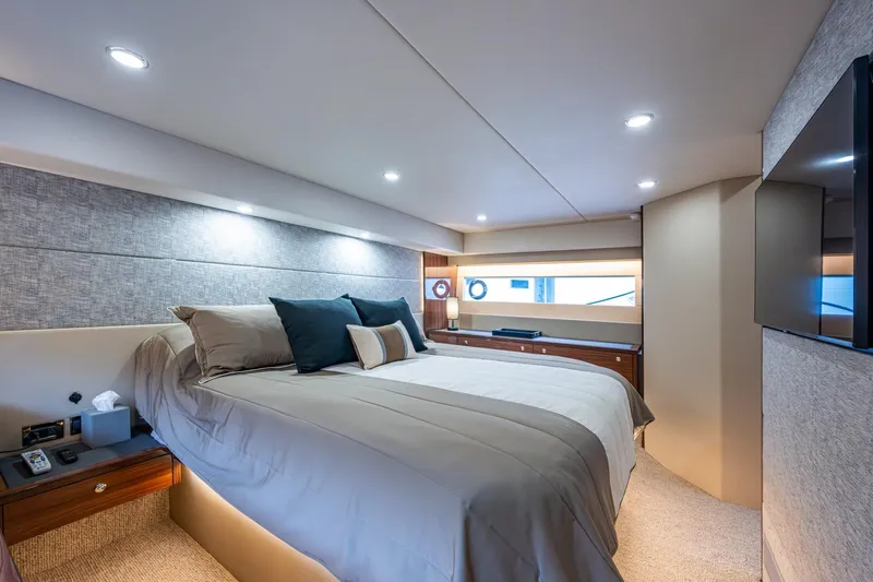 Norfolk Girl Yacht Photos Pics Luxurious bedroom interior of 2023 Maritimo M55 yacht, featuring elegant bedding and modern lighting.