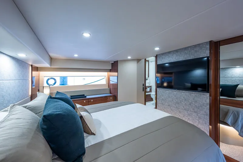 Norfolk Girl Yacht Photos Pics Luxurious bedroom interior of 2023 Maritimo M55 yacht with modern decor and large TV.