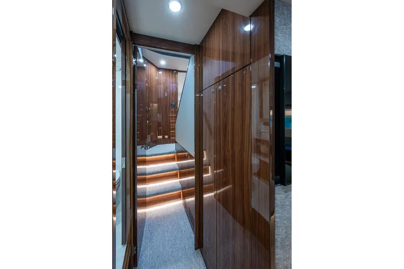 Norfolk Girl Yacht Photos Pics Luxurious interior hallway of 2023 Maritimo M55 yacht with wood paneling and ambient lighting.