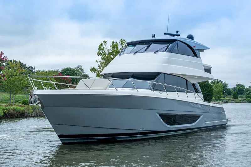 Norfolk Girl Yacht Photos Pics 2023 Maritimo M55 yacht cruising on a serene river with lush greenery.