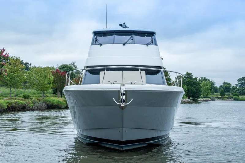 Norfolk Girl Yacht Photos Pics 2023 Maritimo M55 yacht on calm water, surrounded by lush greenery.