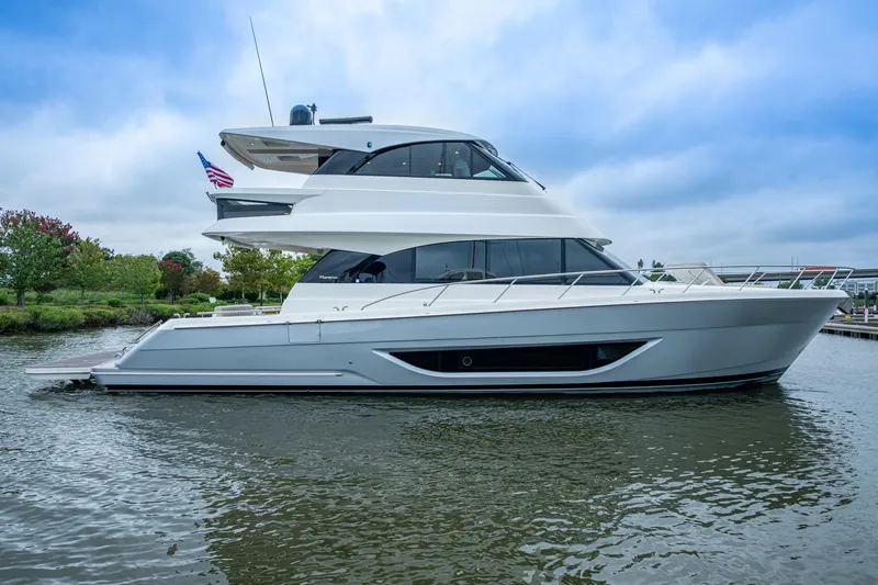 Norfolk Girl Yacht Photos Pics 2023 Maritimo M55 yacht on water, sleek design, American flag, cloudy sky.