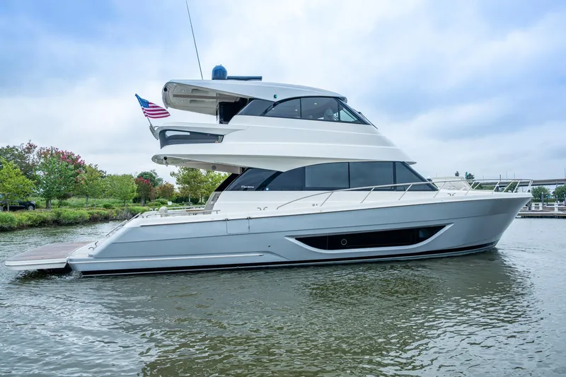 Norfolk Girl Yacht Photos Pics 2023 Maritimo M55 yacht on water, sleek design, American flag, overcast sky.