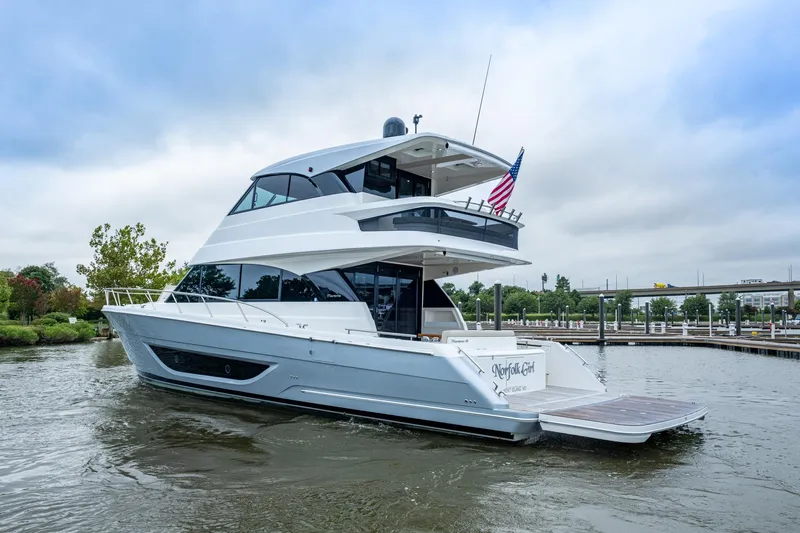 Norfolk Girl Yacht Photos Pics 2023 Maritimo M55 yacht cruising on a calm river near a marina.