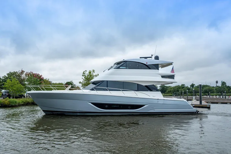 Norfolk Girl Yacht Photos Pics 2023 Maritimo M55 yacht docked on a calm waterway under a cloudy sky.