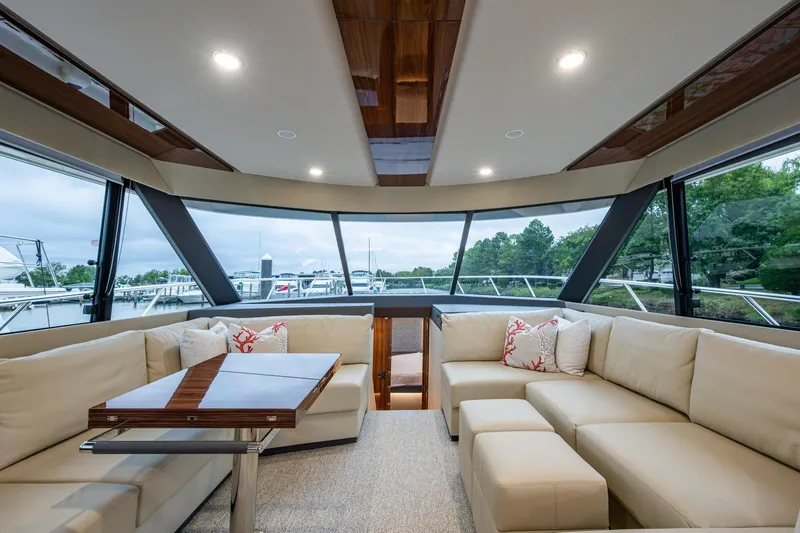 Norfolk Girl Yacht Photos Pics Luxurious interior of 2023 Maritimo M55 yacht with elegant seating and panoramic windows.