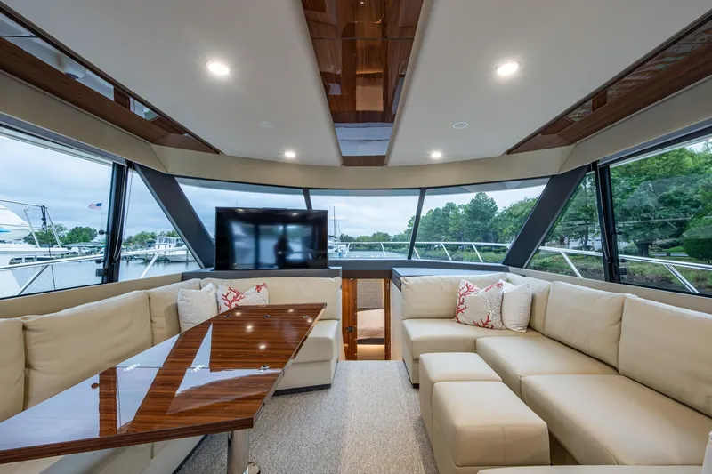 Norfolk Girl Yacht Photos Pics Luxurious interior of 2023 Maritimo M55 yacht with plush seating and panoramic windows.