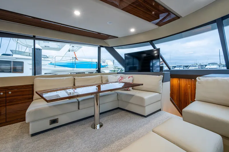 Norfolk Girl Yacht Photos Pics Luxurious interior of 2023 Maritimo M55 yacht with plush seating and panoramic windows.