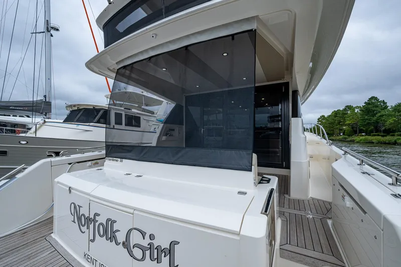 Norfolk Girl Yacht Photos Pics 2023 Maritimo M55 yacht with sleek design, docked near other boats.