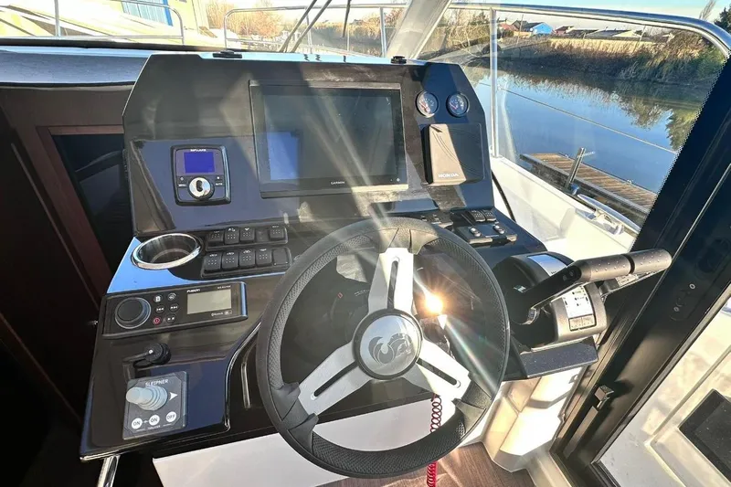  Yacht Photos Pics 2024 Beneteau Antares 11 OB helm with modern controls and navigation equipment.