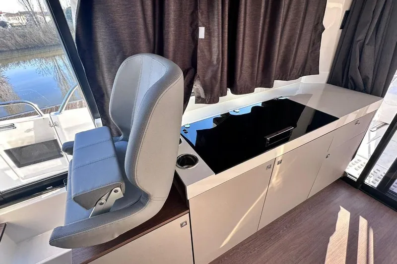  Yacht Photos Pics 2024 Beneteau Antares 11 OB interior with helm seat and sleek cabinetry.