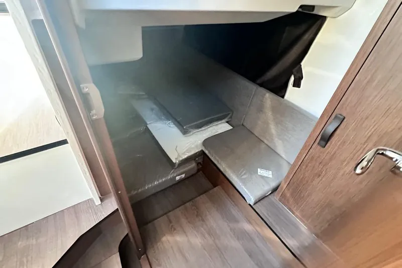  Yacht Photos Pics 2024 Beneteau Antares 11 OB cabin interior with seating and storage space.
